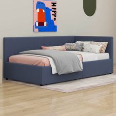 a blue bed sitting on top of a wooden floor