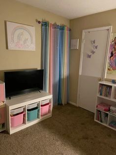 a child's bedroom with pink, blue and green curtains