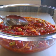 a glass bowl filled with lots of food and a spoon sticking out of the top