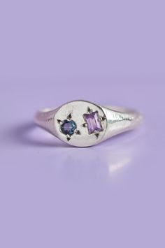 Experience the perfect blend of elegance and playfulness with our Delicate Pickles Mini Signet. Its eye-catching gemstones, including a mesmerizing blue-green Sapphire and an Amethyst, star-set in the face, make it a must-have for those who love to have fun with their jewellery. Use the drop down to select your ring size.If you are unsure of your ring size refer to our size guide. Please select your ring size carefully, and reach out if you have any questions. Details925 Sterling SilverHandcraft Signet Ring With Gemstones, Modern Multi-stone Sapphire Jewelry, Blue Amethyst Jewelry With Gemstone Accents, Formal Blue Amethyst Ring, Blue Amethyst Multi-stone Jewelry, Purple Multi-stone Gemstones For Gift, Blue Amethyst Birthstone Jewelry, Blue Oval Amethyst Jewelry, Blue Multi-stone Amethyst Ring As Gift