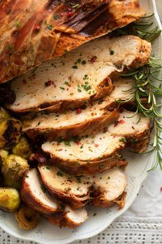 sliced pork roast on a plate with brussel sprouts