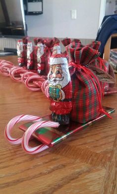 a wooden table topped with lots of candy canes and santa clause on top of it