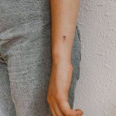 a person with a small tattoo on their left arm and the other hand behind her