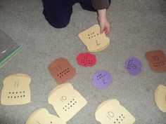 a person kneeling down on the floor with some pieces of paper in front of them