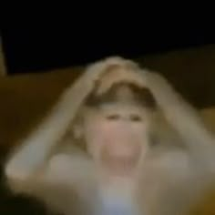 a blurry image of a woman with her hands on her head