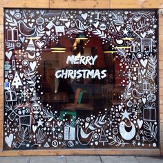 a merry christmas window is decorated with doodles