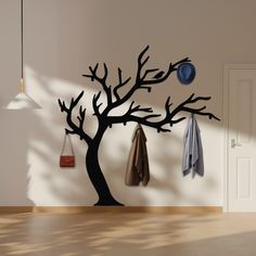 the coat rack is next to a tree with two coats hanging from it's branches