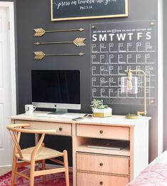 a desk with a computer on top of it and an arrow drawn on the wall