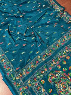 Gorgeous Teal Color saree with handwoven Kantha stitch work in Mutli color. Please note - The edging on the pallu end is done by the weaver with the same kantha stitch work and not done with machine. Item: SareeColor : Teal Color Base Fabric: Bangalori Silk Blouse piece : YesBlouse material: Bangalori Silk Work: Handloom, Kantha Work Fall & Edging (Yes/No) : Yes Occasion: Party, Festival, Traditional, Religious, House-warming. Kindly note : Since this Saree is handmade hence little inconsistenci Festive Embroidered Paithani Silk Saree, Bohemian Blouse Piece With Zari Weaving For Navratri, Navratri Embroidered Paithani Silk Saree, Embroidered Paithani Silk Saree For Navratri, Festive Embroidered Paithani Silk Traditional Wear, Multicolor Embroidered Saree For Puja Festivals, Bohemian Blue Raw Silk Traditional Wear, Paithani Silk Embroidered Saree Fabric For Navratri, Embroidered Paithani Silk Saree Fabric For Navratri