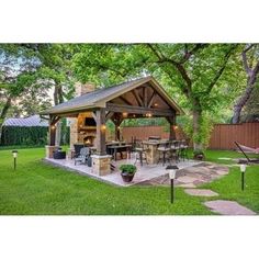 an outdoor kitchen and dining area in a backyard