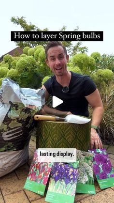 a man sitting on the ground next to some bags and flowers with text reading how to layer spring bulbs