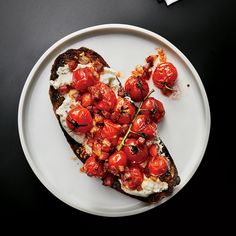 a white plate topped with toast covered in tomatoes