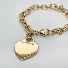 This is part of Chairish’s Fine Jewelry assortment.  A very fine Tiffany Co. bracelet.  In 18k gold.  With slightly oval links and a heart-shaped pendant charm.  The charm is not engraved.  Simply wonderful, classic Tiffany design!  Date: 20th Century  Overall Condition: It is in overall good, as-pictured, used estate condition with some very fine light surface scratches and other signs of expected light wear consistent with age.  Fineness: Marked 750 for 18k gold fineness.  Marks: Tiffany Co. / Classic Gold-tone Charm Bracelet, Classic Bracelets With Logo Charm As A Gift, Luxury Gold-tone Tarnish Resistant Charm Bracelet, Elegant Gold-tone Charm Bracelet With Logo, Classic Formal Jewelry With Heart Charm, Elegant Heart Bracelet With Charms, Engraved Classic Charm Bracelet, Classic Gold-tone Charm Bracelet, Tarnish Resistant, Classic Gold-tone Tarnish Resistant Charm Bracelet