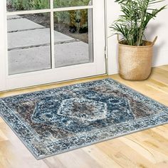 a large blue rug sitting on top of a hard wood floor next to a door