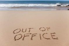 the word out of office written in sand at the beach with waves coming in to shore