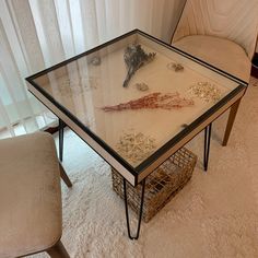 a glass table topped with lots of different items on top of a white carpeted floor