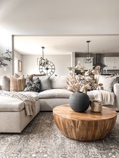 a living room filled with lots of furniture next to a large white couch and coffee table