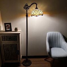 a lamp that is sitting on top of a floor next to a chair and table