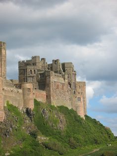 an old castle sitting on top of a lush green hillside