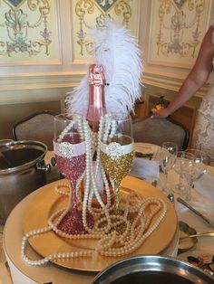 the table is set with wine glasses, pearls and other things on it's plate