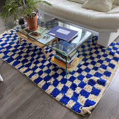 a living room area with a couch, coffee table and books on the rugs