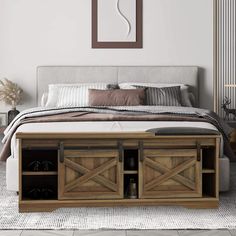 a bedroom with a large bed and wooden storage drawers on the bottom shelf in front of it