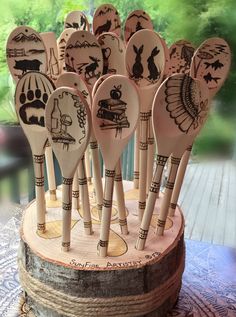 several wooden spoons with designs on them sitting on a table in front of a window