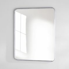 a bathroom mirror sitting on top of a white wall