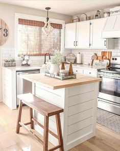 a kitchen with white cabinets and wooden stools