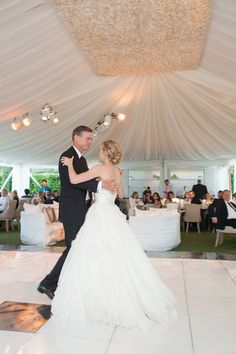 a bride and groom dance on the dance floor