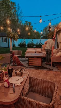 an outdoor patio with wicker furniture and string lights strung over the back deck area