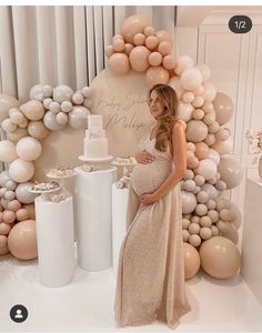 a pregnant woman standing in front of a table with cake and desserts on it