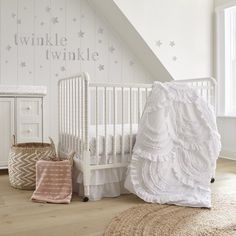 a baby's room with white furniture and stars on the wall, including a crib