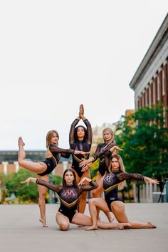 a group of young women standing next to each other on top of a cement ground