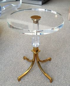 a glass table with gold legs on carpeted floor