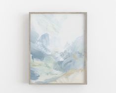 an abstract painting hangs on the wall next to a white wall with a wooden frame