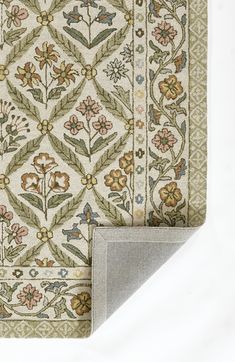 the corner of a rug with flowers and leaves on it