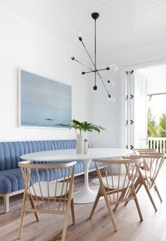 a dining room table with four chairs and a blue bench