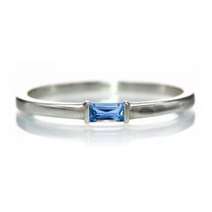 a white gold ring with a blue topazte stone