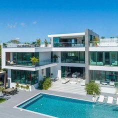 an aerial view of a house with a pool and lounge chairs in the foreground