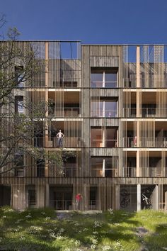 an apartment building with wooden slats on the sides and balconies on the upper floor