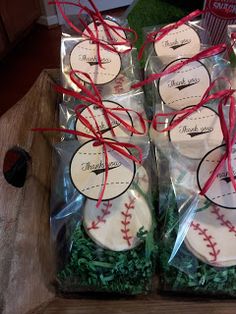 baseball themed cookies wrapped in plastic and tied with red twine on wooden table top