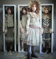 three mannequins are standing in front of two identical dolls, one with red hair and the other without