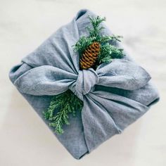 a wrapped present with a pine cone on top