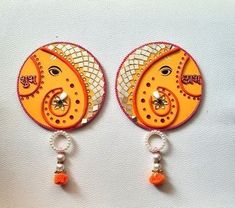 two orange and white earrings with beads on them