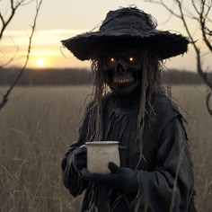 a creepy scarecrow holding a mug in a field