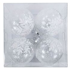 four white christmas ornaments in a clear box