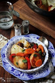 a blue and white plate topped with meat and veggies