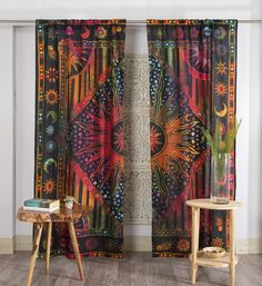 the curtains in this room are decorated with bright colors and patterns, along with a small table