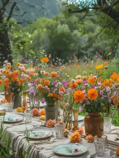 an outdoor table set with flowers and plates on it for a dinner party or gathering